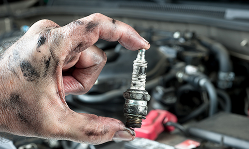 Man with greasy hand holding headlight of a car